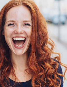 Woman with red hair smiling.