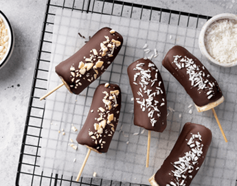 Delicious chocolate covered bananas on a cooling rack. loading=