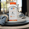 A bottle of 21st Century Vitamin C 1000 mg prolonged release tablets sitting on a dinner plate with a rolled up napkin.