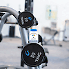 A bottle of 21st Century Vitamin K2 100 mcg MK-7 vegetarian capsules sitting on a barbell on a barbell rack.