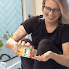 A woman dumping a bottle of 21st Century VitaJoy Biotin 500 mcg gummies into her hands.