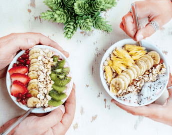 Bowls filled with delicious fruit, granola and yogurt.