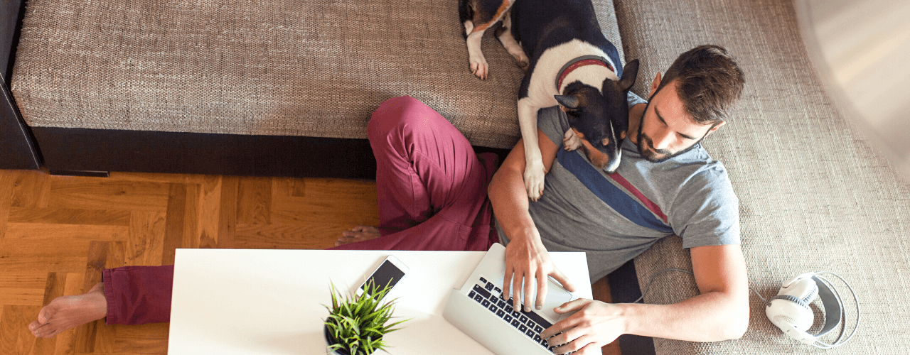 Young man sitting in his living room working on a laptop.