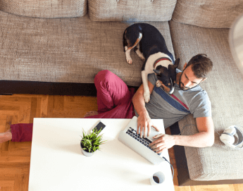 Young man sitting in his living room working on a laptop.