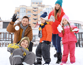 Family playing outside in the snow.