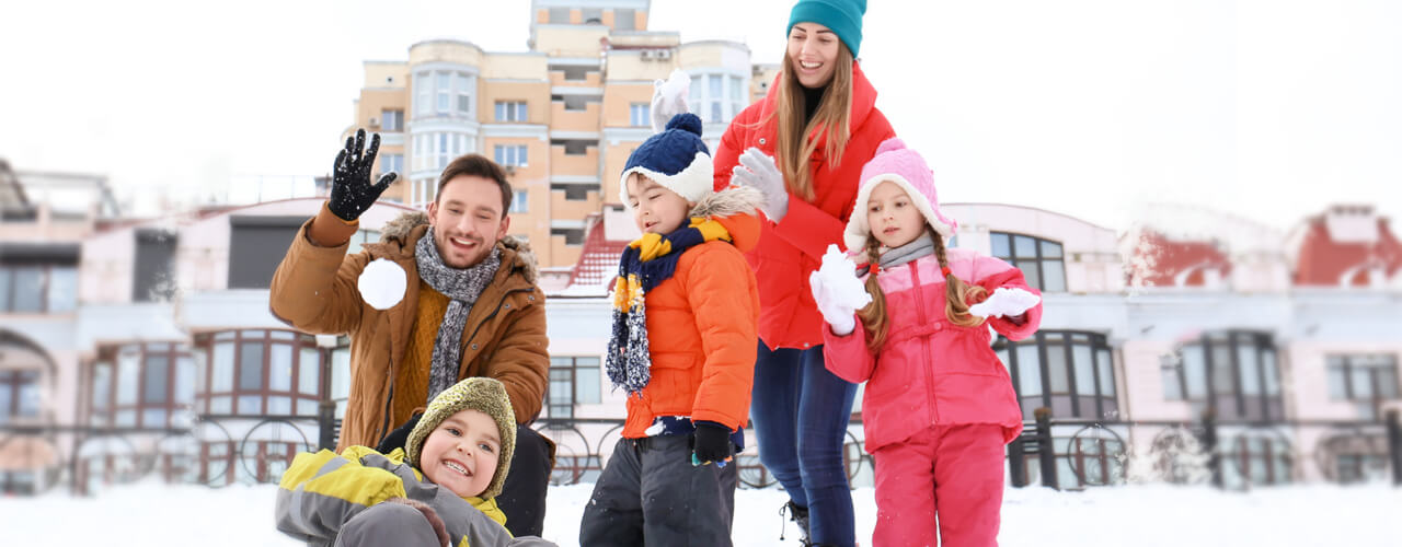 Family playing outside in the snow.