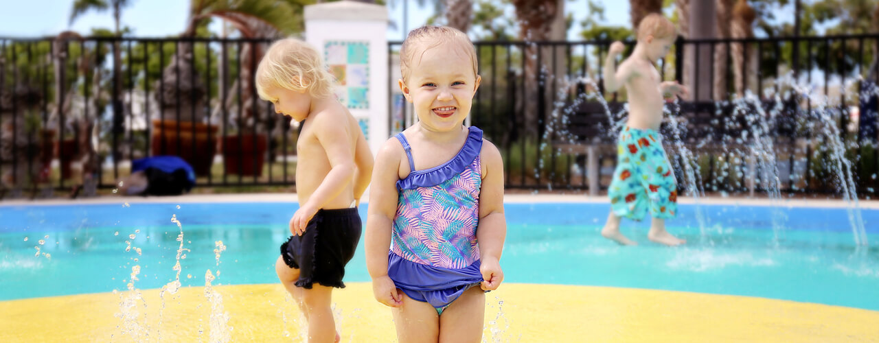 A group of young children playing at a splash pad.