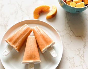 Box of ImmuBlast-C next to fresh peaches and popsicles on a plate