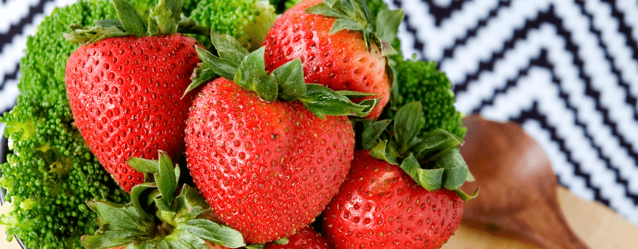 A bowl of strawberries and broccoli