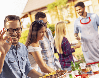 Man and women picking up food at a buffet.