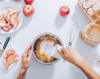 A top view of prepping and mixing ingredients to make apple pie.