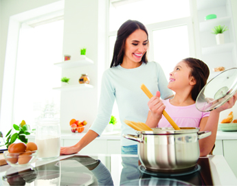 Mom and daughter cooking together in the kitchen.