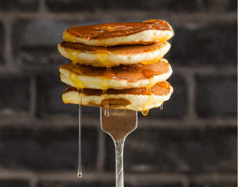 A yummy stack of pancakes on a fork.