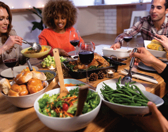 A group of people sitting at a dining room table enjoying Thanksgiving dinner.