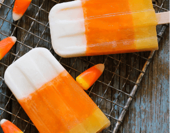 Top view of Halloween candy corn and candy corn popsicles on a kitchen counter.