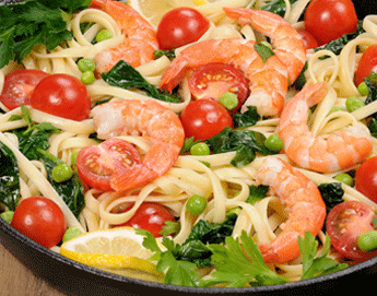 A bowl of pasta mixed with tomatoes, peas and shrimp.